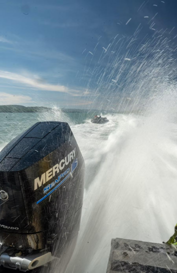 Speedboat cutting through ocean waves with spray